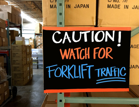 Image of warehouse caution chalkboard paper sign on shelving with caution watch for forklift traffic written on sign using 15mm bold tip Safety Marker by Chalk Ink