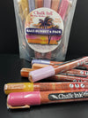 Closeup of chalk ink liquid chalk variety pack of markers on a black table in front of chalk ink Maui Sunset packaging