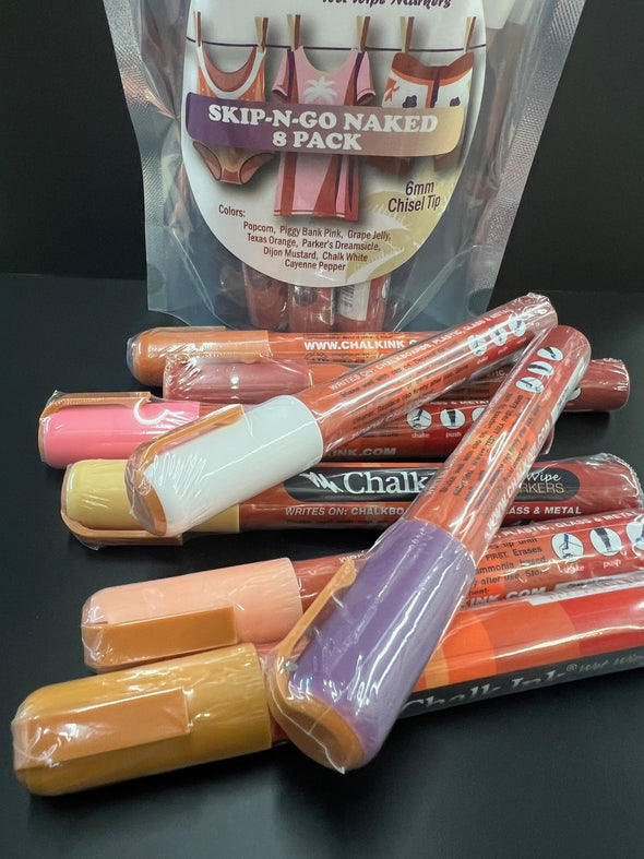 Closeup product image of chalk ink liquid chalk marker variety pack on a black table in front of skip and go naked chalk marker packaging