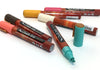 Closeup top view of chalk ink liquid chalk markers in 70's retro inspired colors laying on a white counter