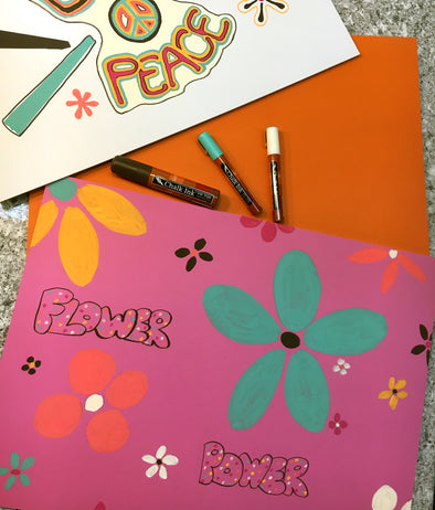 Image of pink, orange and white chalkboards with retro 70's style flowers and peace sign drawn using chalk ink liquid chalk markers in groovy colors